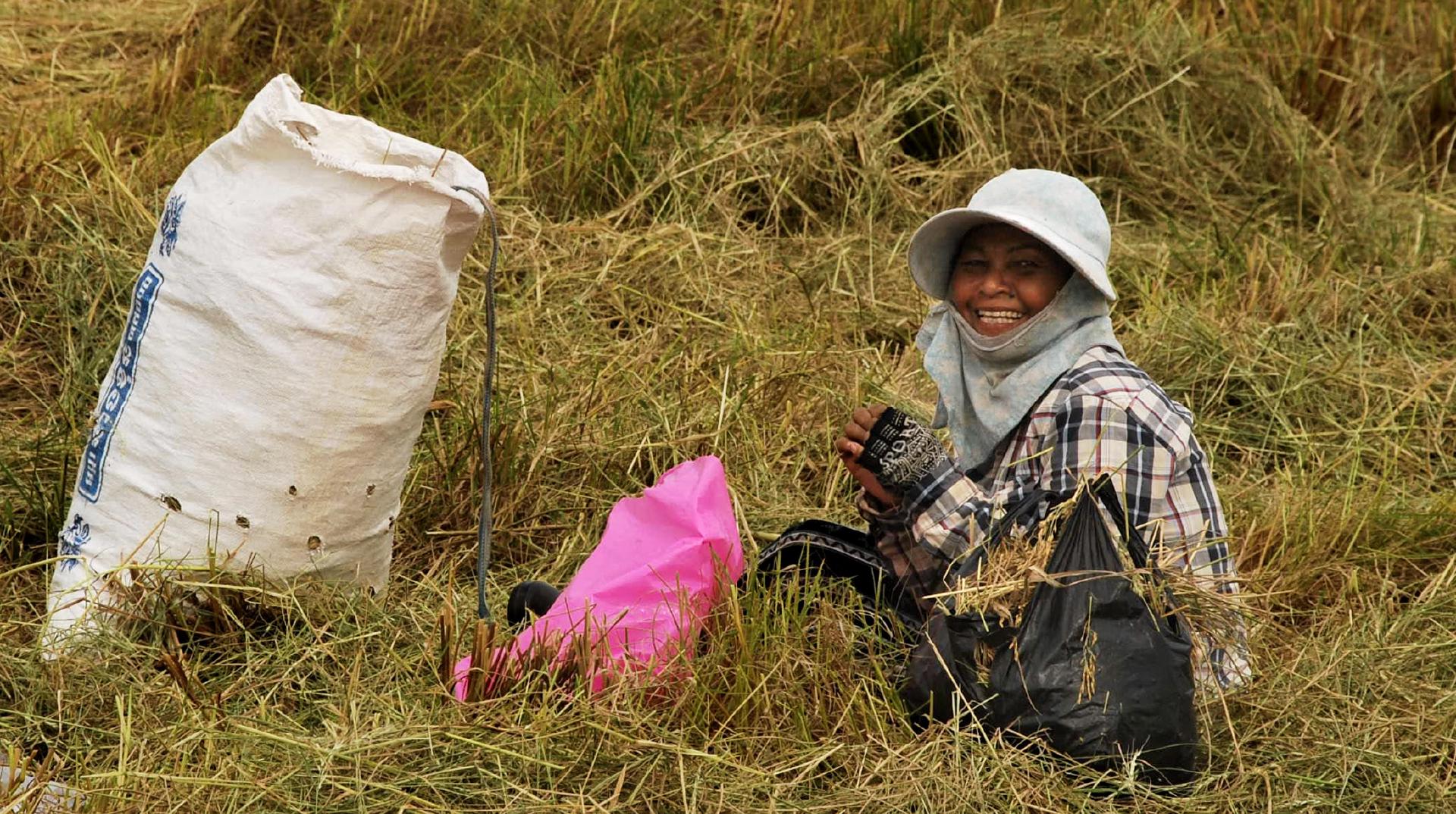 Happy rice farmer gretting cyclists in Kampot