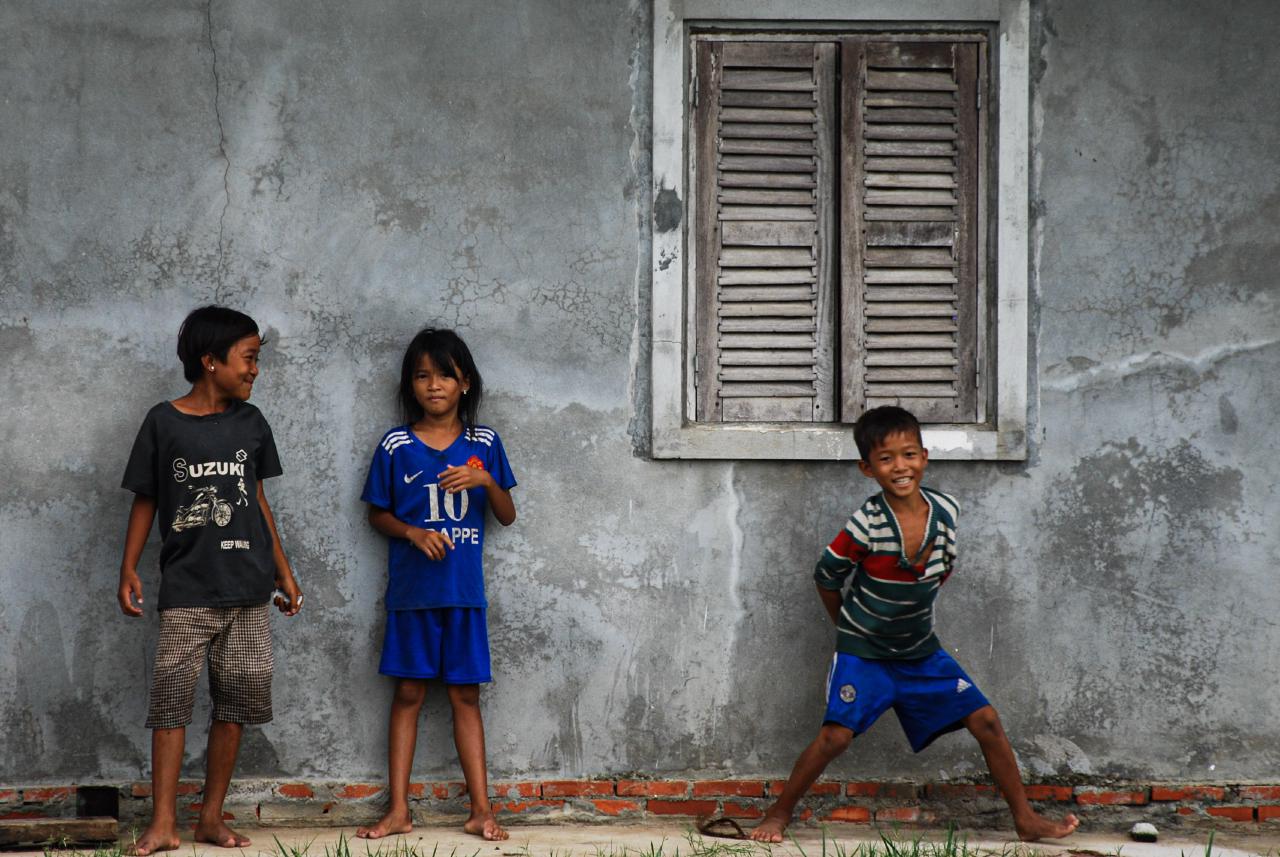 Kids waving as cyclists pass through the village